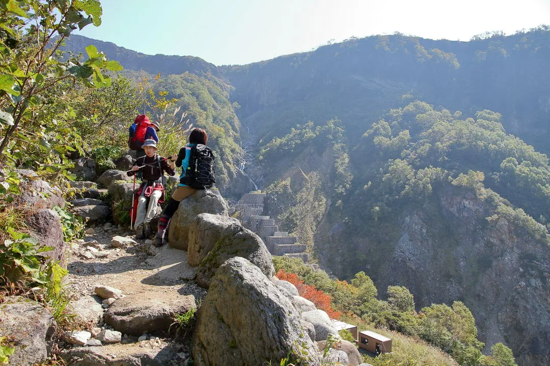 不動滝を眺めて休む登山者