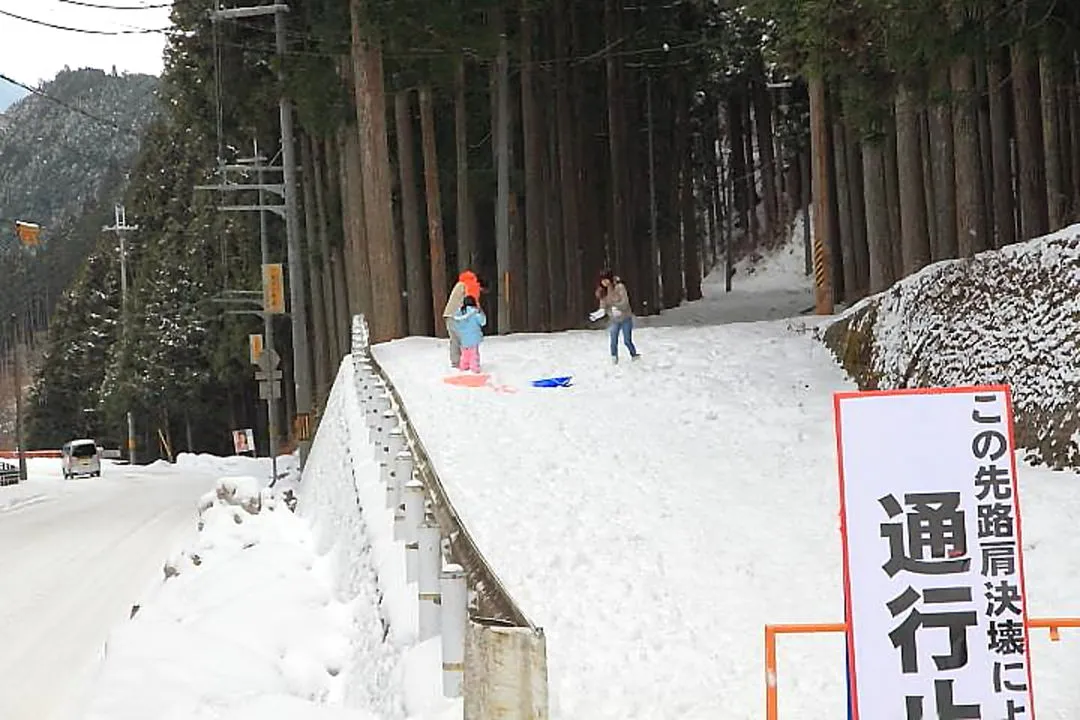 ソリ遊びをする家族